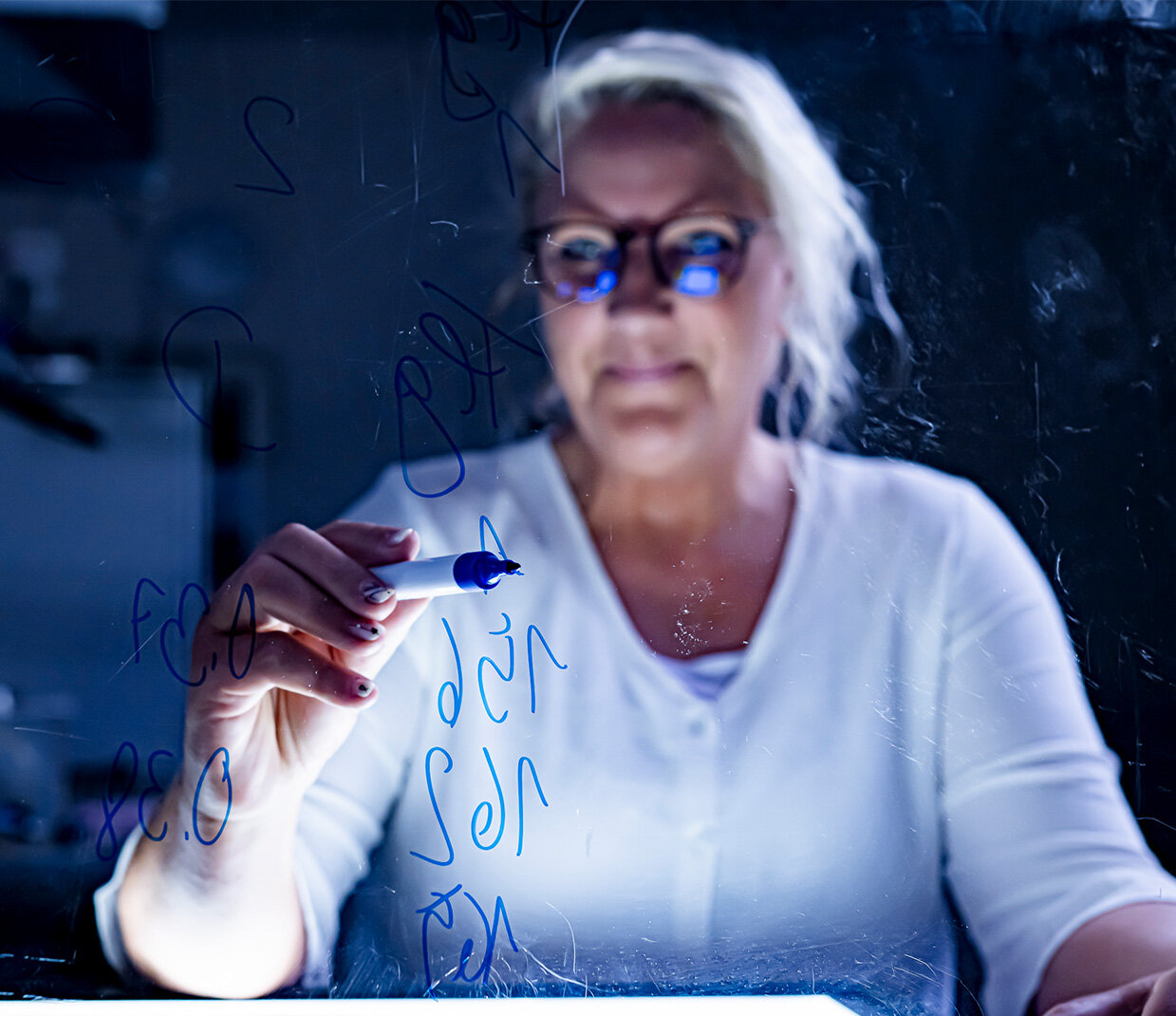 Woman writes on blackboard | Change Story | Sandler Group