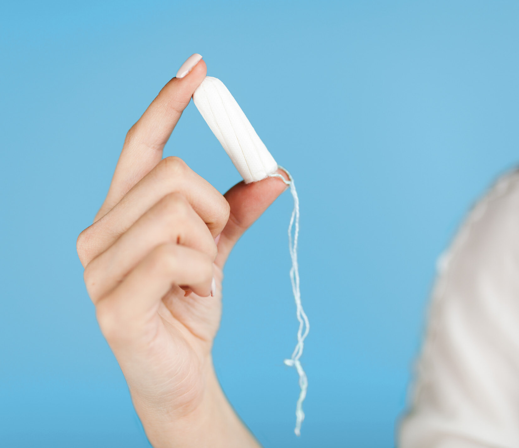 Eine Hand hält einen Tampon.