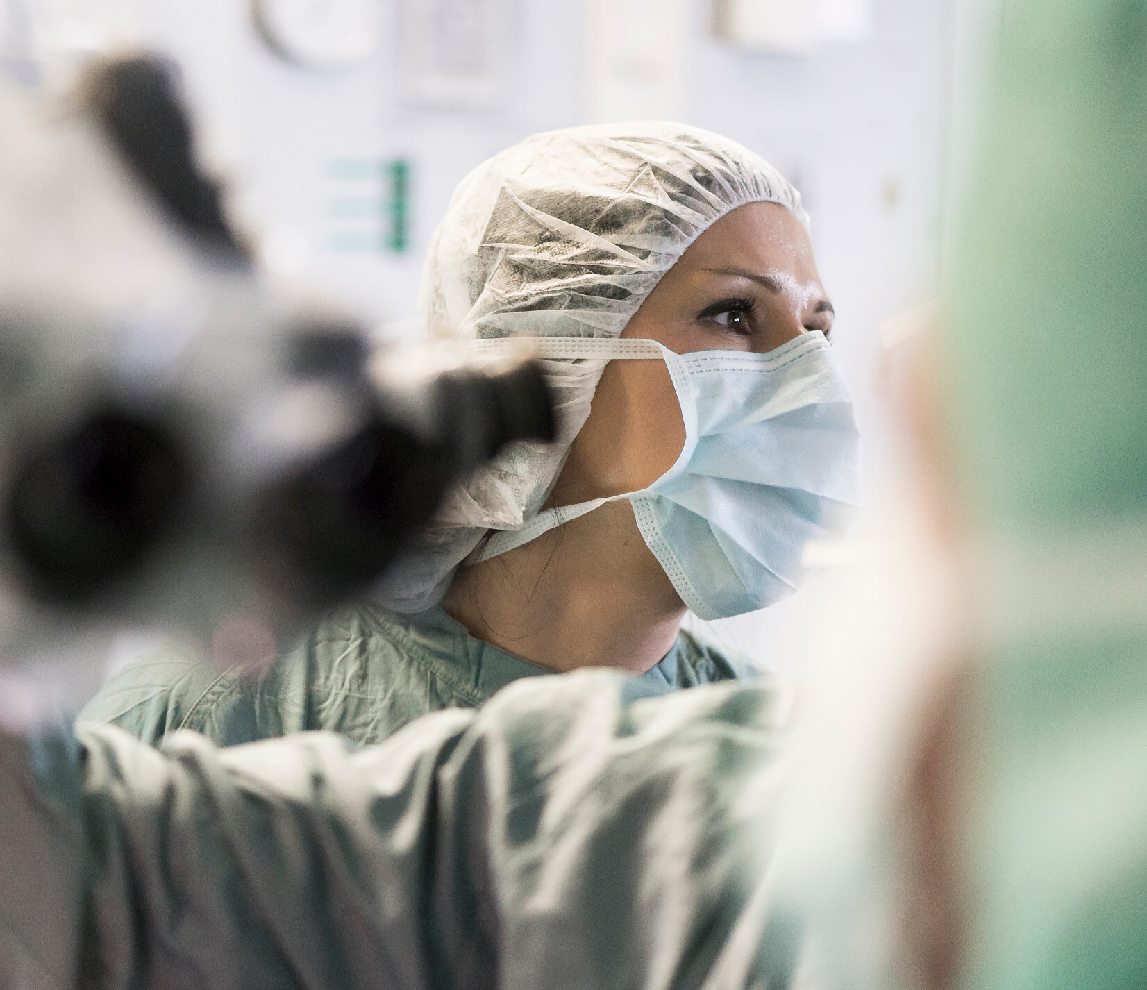 Frau im OP-Saal mit Maske aus Vliesstoff