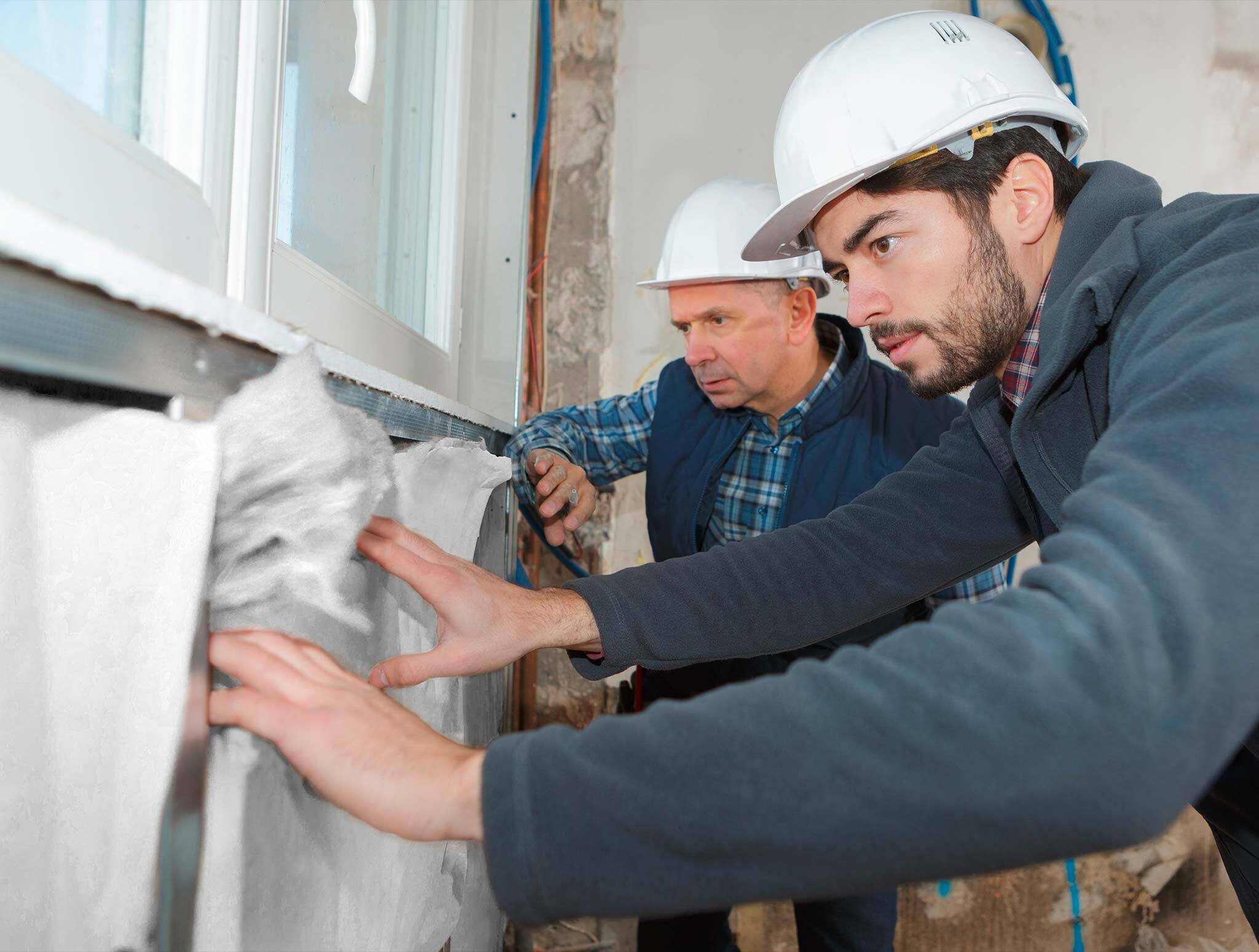 Anbringen von Vliesstoff durch zwei Bauarbeiter | Sandler Group