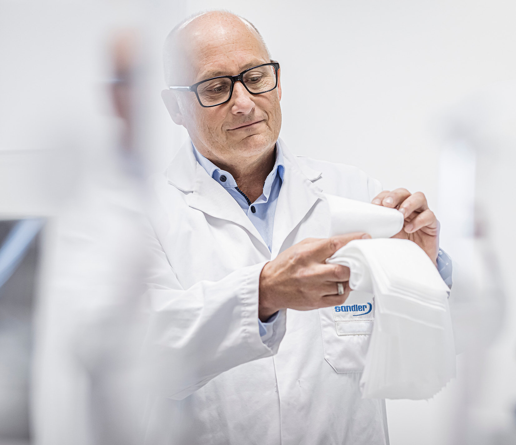 Männlicher Mitarbeiter der R&D-Abteilung bei Sandler hält Nonwoven Innovationen in der Hand