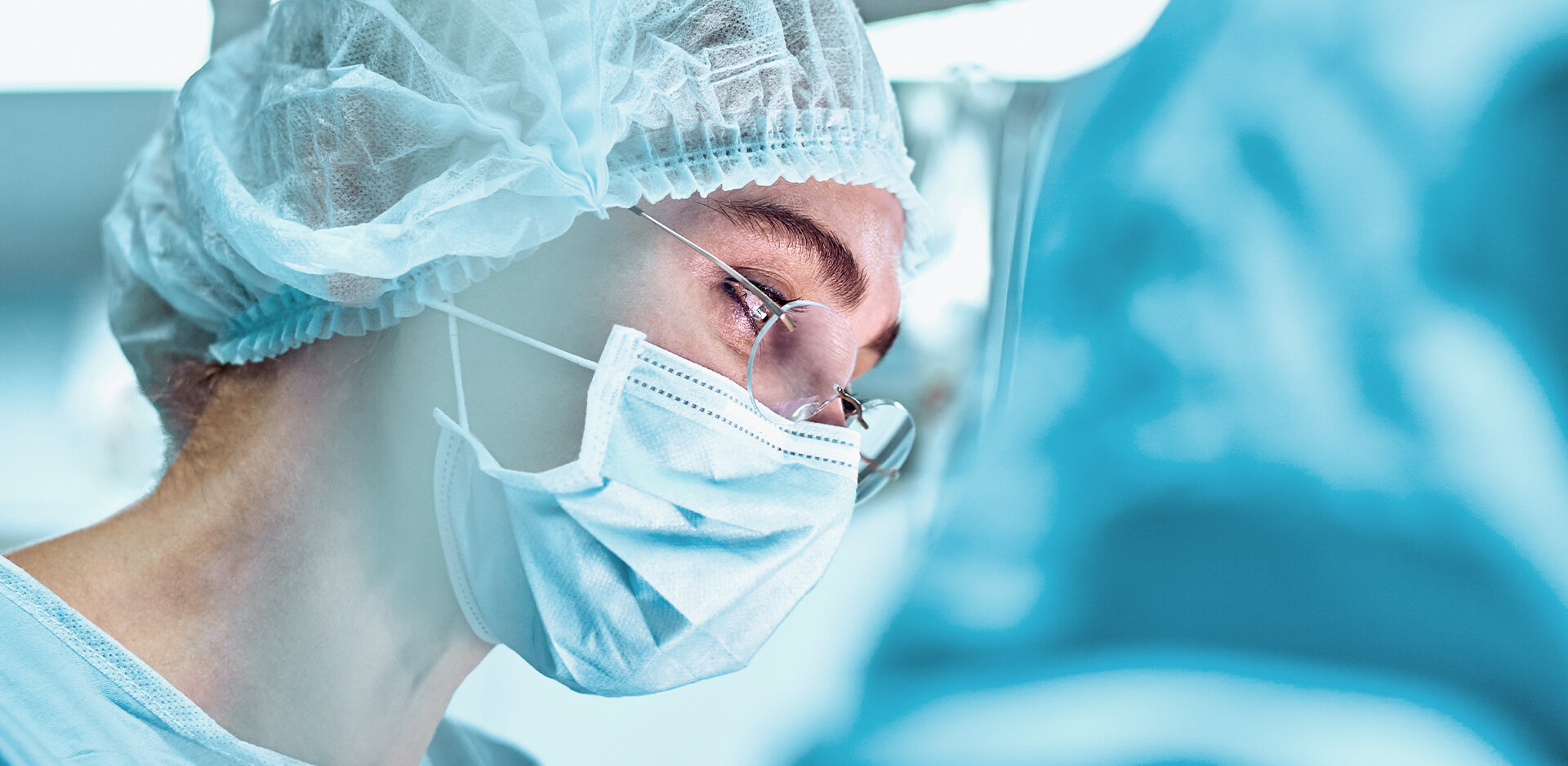 Woman in protective clothing with hood and mask | Sandler Group 